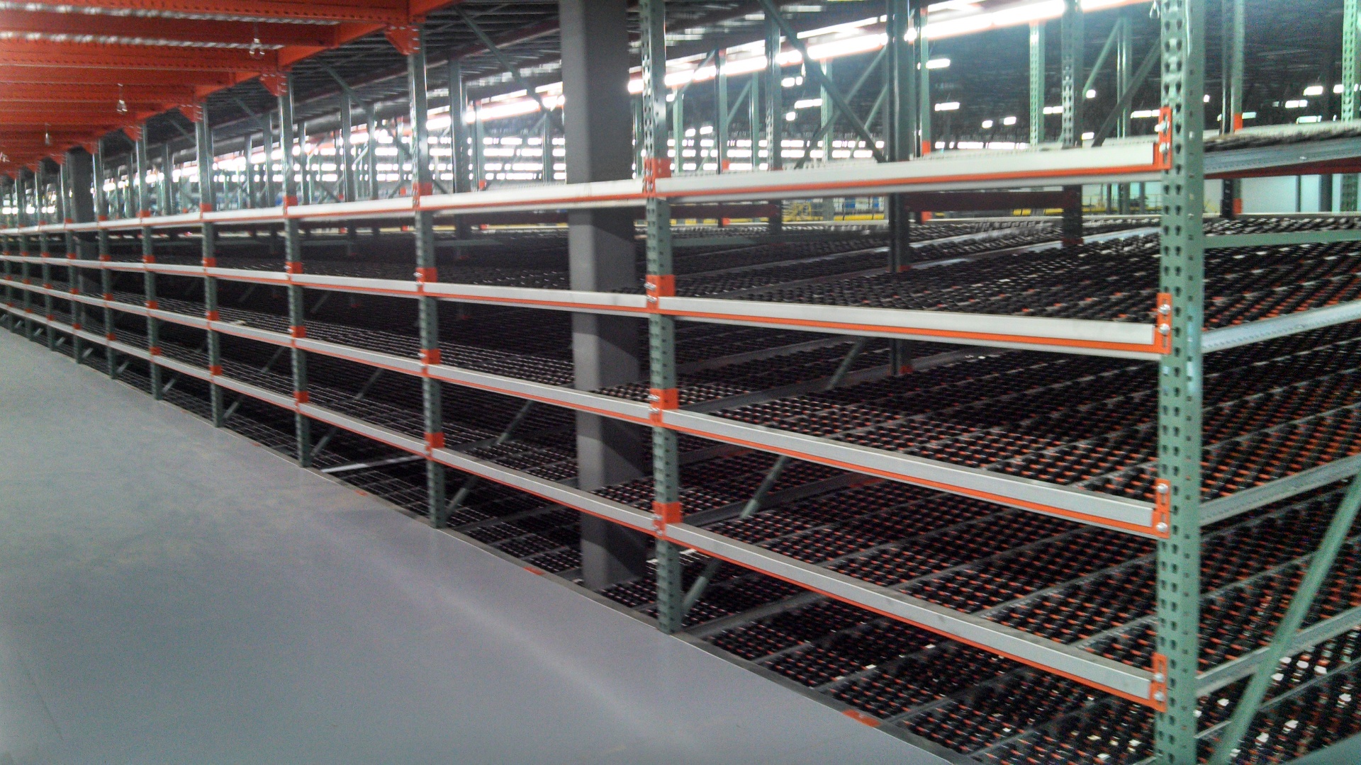 Long run of carton flow rack with gravity roller lanes installed in a large distribution center