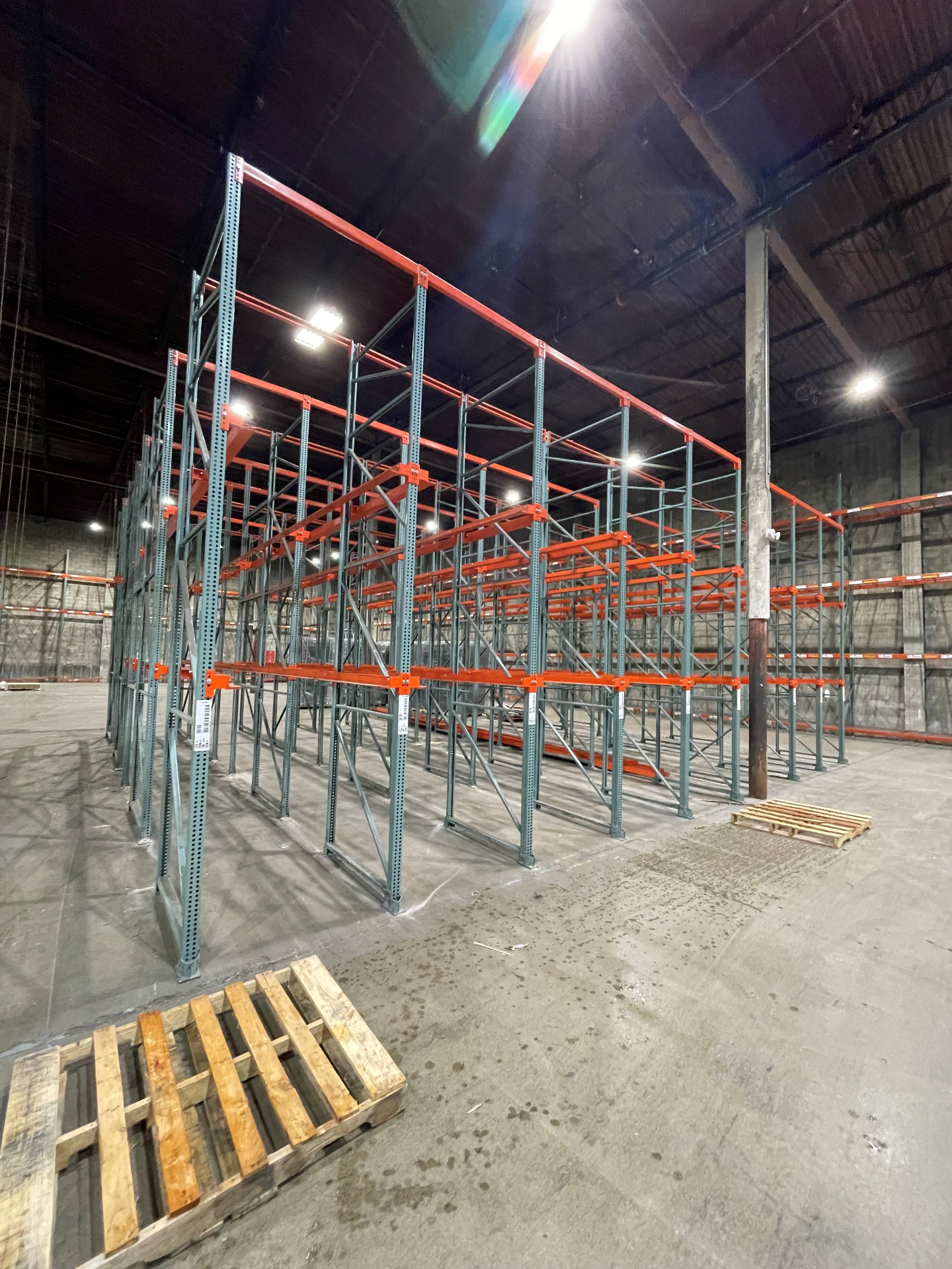 Drive-in pallet racking system with orange beams and green uprights in Columbus OH warehouse