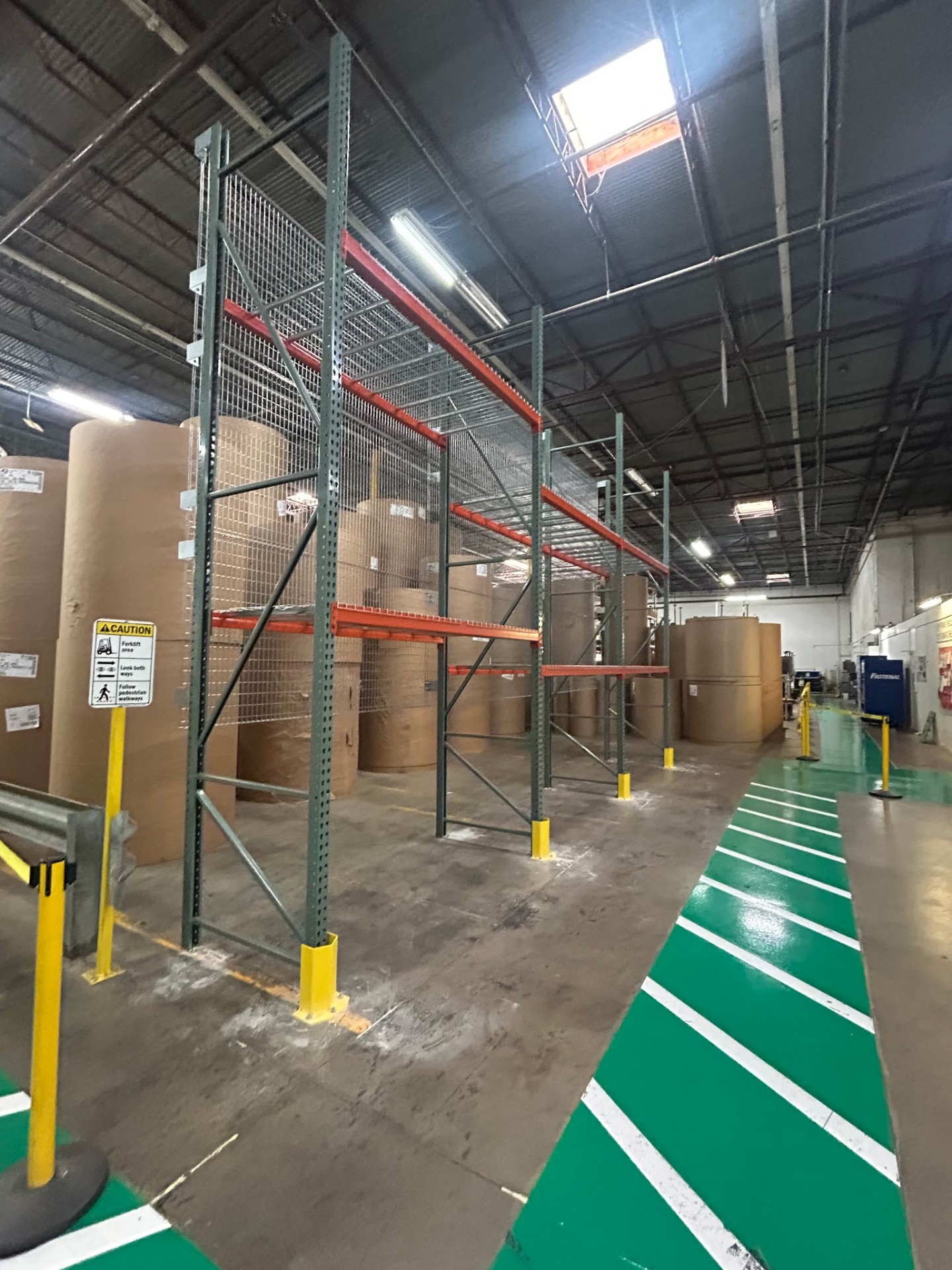 Pallet racking with wire mesh rack back guards and column protectors storing large paper rolls in Dallas TX facility